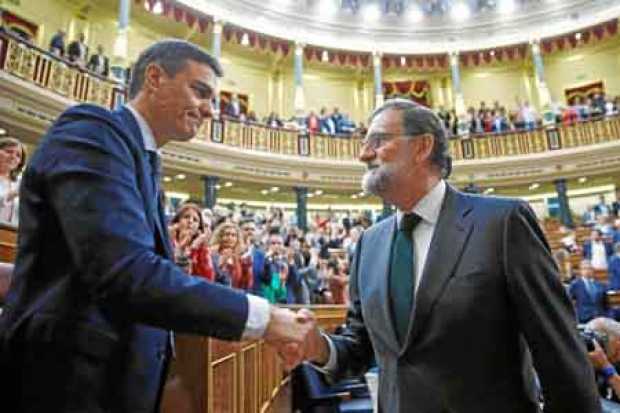 El socialista Pedro Sánchez es felicitado por Mariano Rajoy, presidente saliente del Gobierno español, tras la segunda jornada d