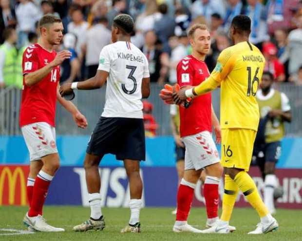 El portero francés Steve Mandanda y su compañero Presnel Kimpembe saludan a los jugadores daneses Christian Eriksen Henrik Dalsg