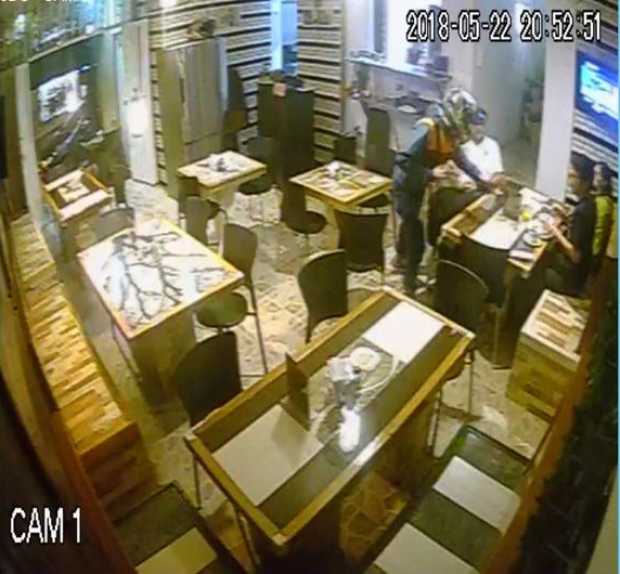 Foto | LA PATRIA Momento en que un hombre, cubierto con un casco, atraca a quienes estaban en el restaurante.