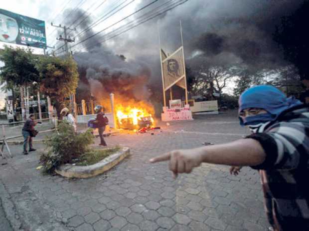 Foto | EFE | LA PATRIA  Vista de un vehículo incendiado en la cooperativa de ahorro y crédito Caruna, en Managua (Nicaragua).