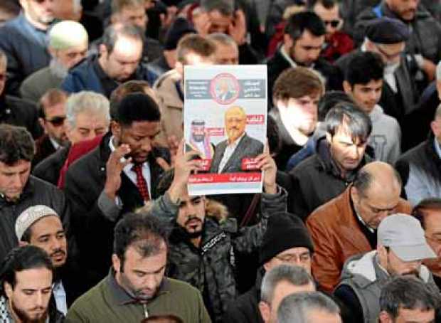 Hombres sostienen una imagen del periodista opositor saudí Jamal Khashoggi mientras rezan en la mezquita Fatih, en Estambul (Tur