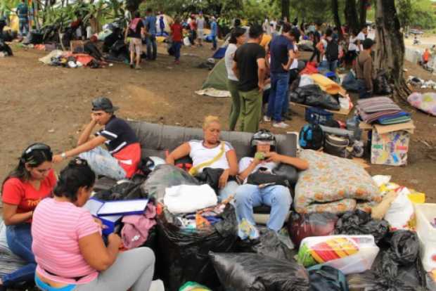 Migrantes apostados a las afueras del terminal de transporte.