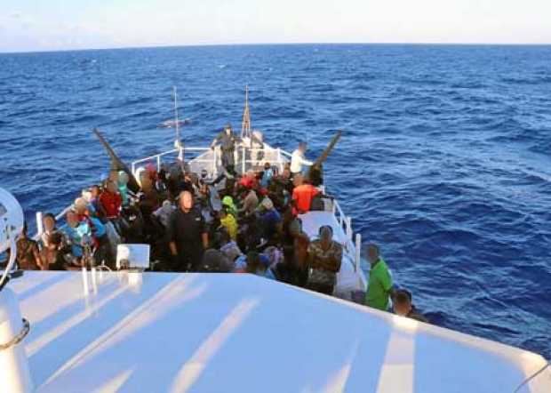 Foto | Efe | LA PATRIA Grupo de migrantes haitianos (146) sentados en la cubierta del bote perteneciente al guardacostas estadou