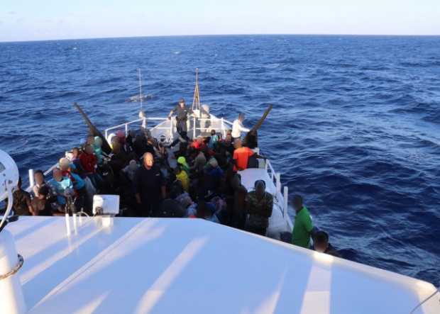 Grupo de migrantes haitianos (146) sentados en la cubierta del bote perteneciente al guardacostas estadounidense William Trump, 