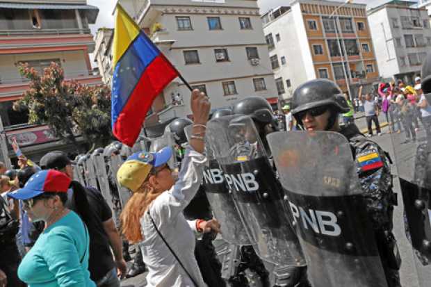 Simpatizantes del líder del Parlamento, Juan Guaidó, se manifiestan este sábado cerca de la avenida Victoria, en Caracas (Venezu