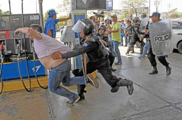 Foto | EFE | LA PATRIA  Miembros de la Policía Nacional intentaron el sábado detener al reportero gráfico Luis Sequeira, de la a