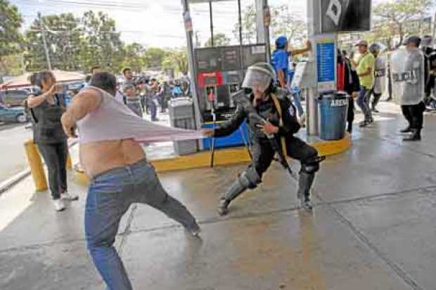Miembros de la Policía Nacional intentaron detener al reportero gráfico Luis Sequeira, de la agencia AFP, durante una manifestac