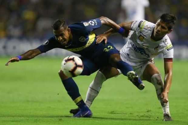  Sebastián Villa (i) de Boca Juniors disputa el balón con Rafael Carrascal de Deportes Tolima 