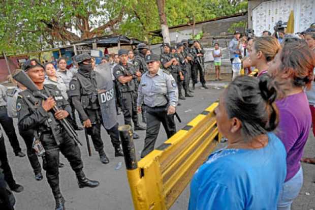 Un grupo de familiares de presos políticos se planta frente a varios agentes antidisturbios de la Policía Nacional para exigir i