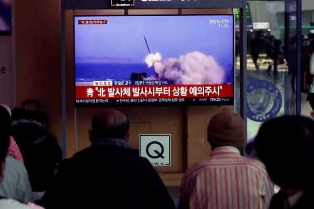 Varios surcoreanos siguen por televisión el lanzamiento de una serie de proyectiles no identificados desde Corea del Norte, en l