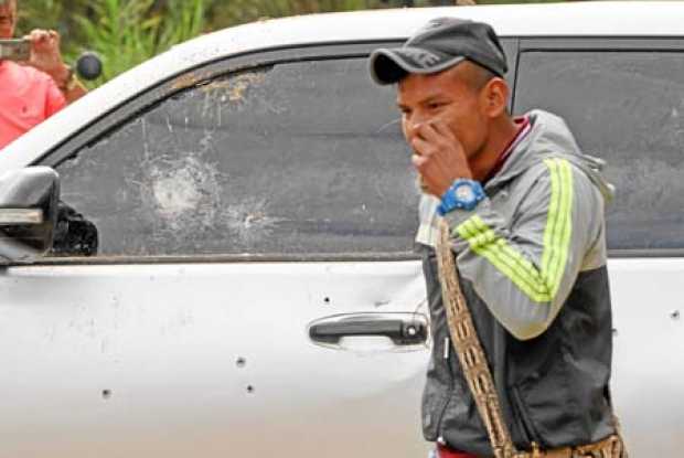 Un indígena camina cerca del carro en el que se transportaban cinco indígenas que fueron asesinados en Tacueyó (Cauca). 