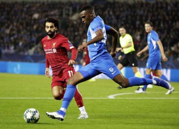 Jhon Lucumí despeja la pelota ante la presión de Mohamed Salah. 