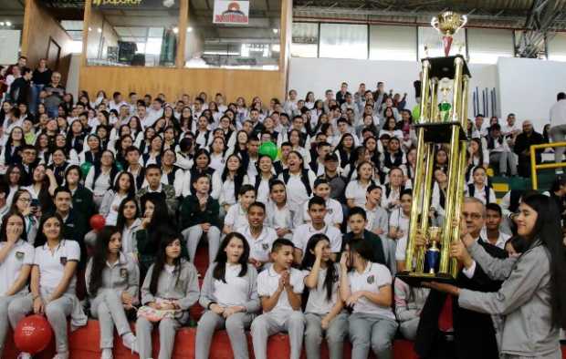 El rector de Bosques del Norte, José Manuel González, les ofrece a sus estudiantes el trofeo que los acredita como campeones de 