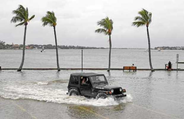 Un vehículo transita por un terreno inundado, antes de la posible llegada del huracán Dorian, en Palm Beach (Florida). 
