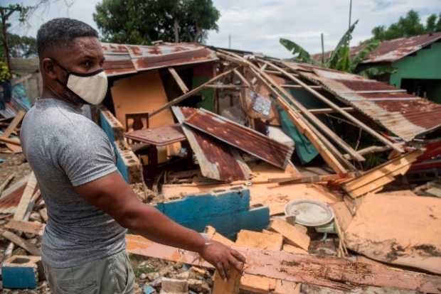 Un hombre intenta reparar su vivienda dañada por el paso del huracán Isaías, el viernes, en Hato Mayor, República Dominicana.