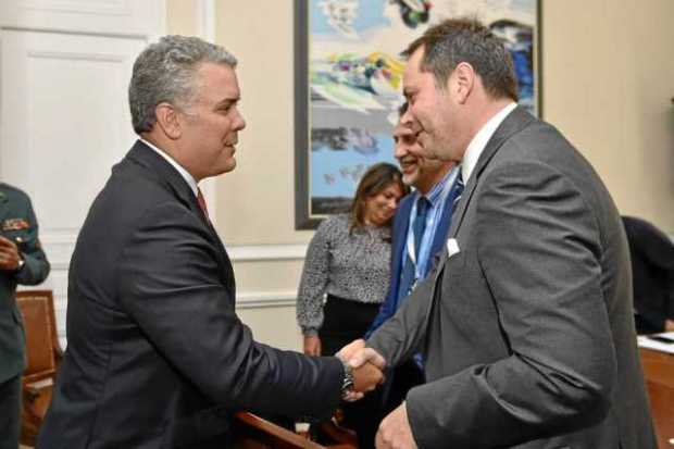 Iván Duque, presidente de Colombia, estrecha una mano de Carlos Ruiz Massieu, jefe de la misión de verificación de la ONU para e