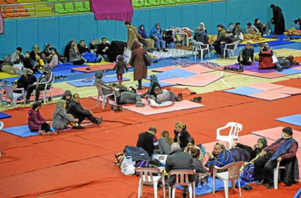 Las personas descansan en un pabellón deportivo cubierto, un refugio temporal, después de un terremoto en Elazig, Turquía, el 26