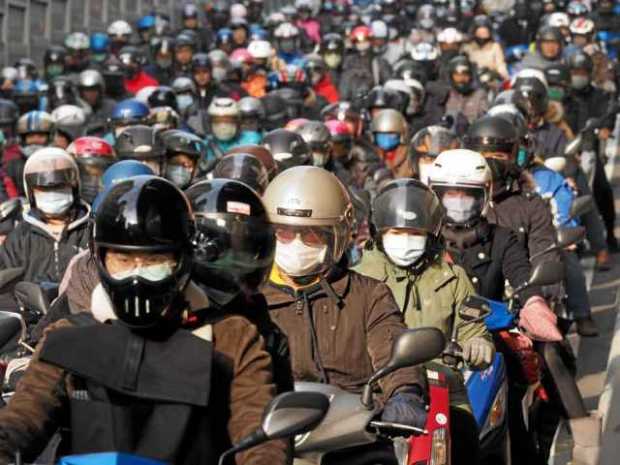 Foto | EFE | LA PATRIA Motoristas conducen con máscaras faciales en Taipei (Taiwán).