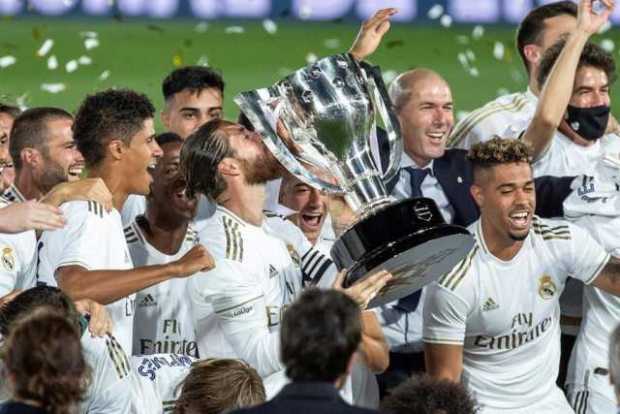 Los jugadores del Real Madrid con el trofeo que les acredita campeones del título de liga en España. 