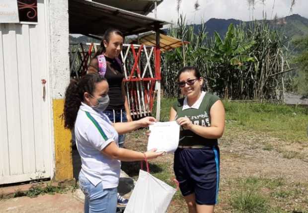 En el corregimiento de Encimadas, la docente Sonia González distribuye cartillas y talleres para sus alumnos.