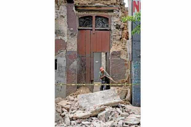 Un hombre quita escombros de un muro derrumbado ayer en Oxaca (México).