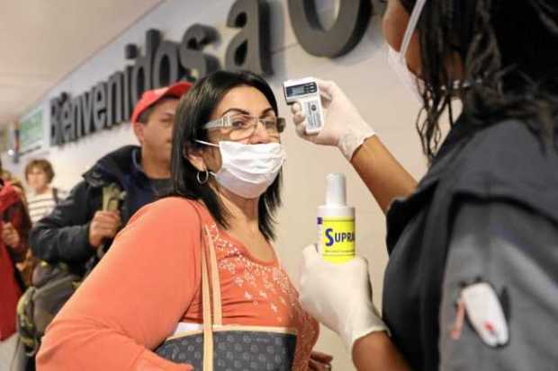 Toma de la temperatura a los ciudadanos que llegan al aeropuerto internacional El Dorado en Bogotá. Migración Colombia manifestó