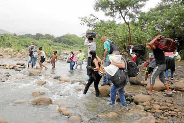 Venezolanos madrugaron a cruzar por los pasos ilegales entre Colombia y Venezuela. En la foto pasando por el río Táchira. 