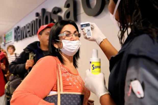 Foto | Efe | LA PATRIA  Toma de la temperatura a los ciudadanos que llegan al aeropuerto internacional El Dorado en Bogotá. Migr