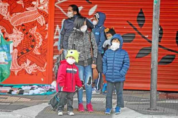 Una familia, todos con mascarilla de protección, permanece cerca a una estación de metro, en Sao Paulo (Brasil). 