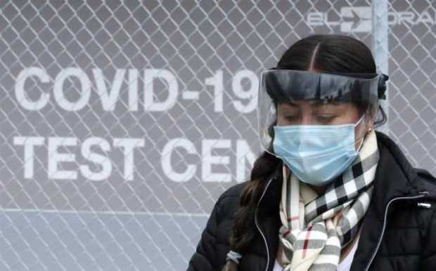 Una mujer pasa frente al laboratorio Synlab en el aeropuerto Internacional El Dorado en Bogotá (Colombia). 