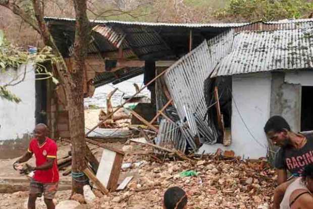 Personas retiran escombros de sus viviendas dañadas en San Andrés. 