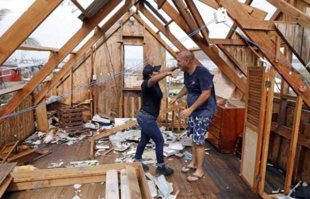Jeanguillaume Misas abraza a su esposa al interior de su casa destruida por el paso del huracán Iota