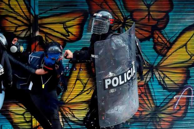 Manifestantes encapuchados y miembros del Escuadrón Móvil Antidisturbios (Esmad) de la Policía se enfrentaron el lunes en la Pla