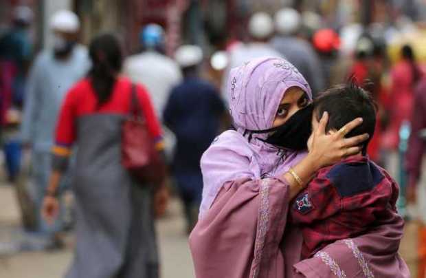 Una mujer con una mascarilla sostiene a su hijo en Bangalore, India, este 7 de septiembre del 2020.