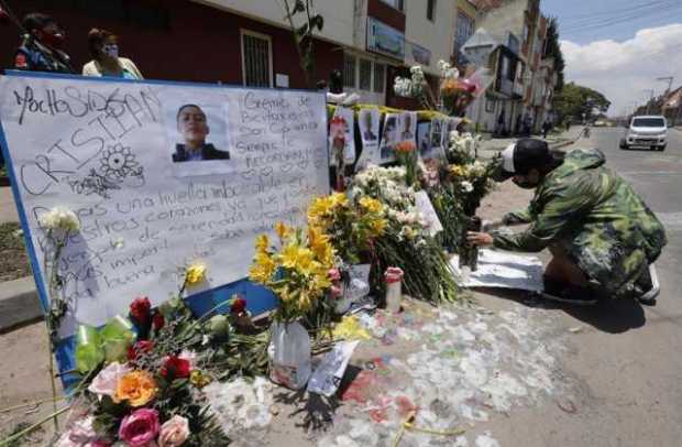 Un hombre pone velas en un altar en memoria de Cristian Hernández, muerto durante disturbios frente al centro de atención inmedi