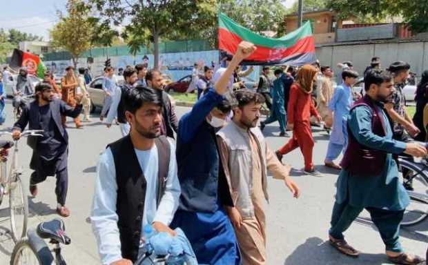 Los afganos sostienen banderas nacionales mientras celebran el Día de la Independencia en Kabul, Afganistán, el 19 de agosto de 