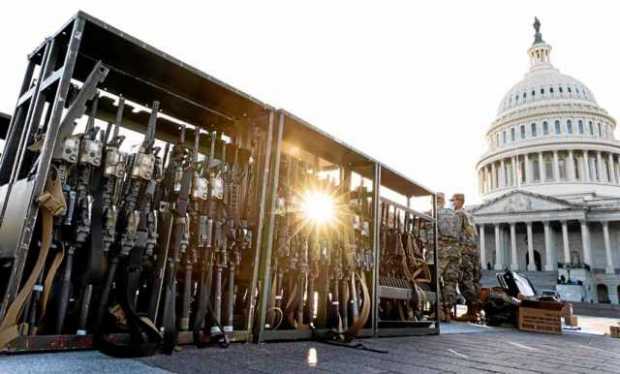 Soldados de la Guardia Nacional organizan cajas de rifles en los terrenos del edificio del Capitolio.