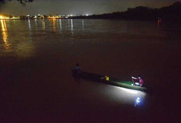 Los pescadores parecen luciérnagas sobre el río Magdalena, luces repartidas que se mueven lentamente por el agua.