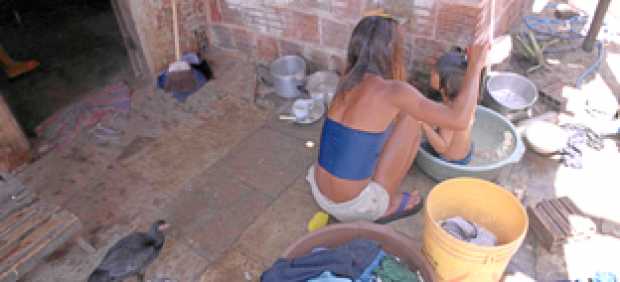 FOTO | Versiani | Unicef | IPS | LA PATRIA Susana, de 14 años, baña a su pequeño sobrino en un barrio pobre de Brasil. La pobrez
