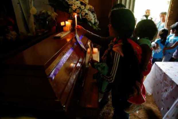 Familiares encienden velas durante el sepelio de José Huberth Tumbo, el viernes en el corregimiento de Pueblo Nuevo, municipio d