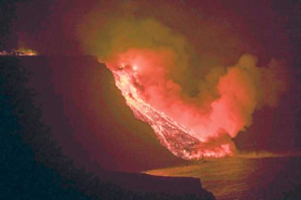 La colada de lava que emerge de la erupción volcánica de La Palma llegó en la noche del martes al mar en una zona de acantilados