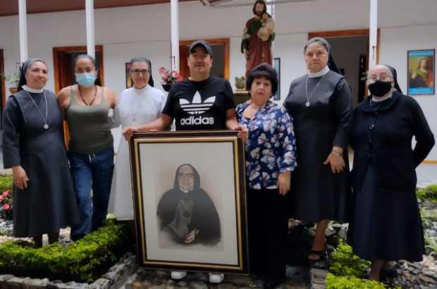Gustavo Cárdenas posa con el cuadro de la Madre Berenice que donó a la Congregación en compañía su madre, su hermana y de las re