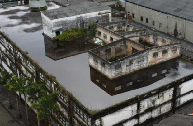 La edificación tiene agua estancada, brotes de maleza y hierros oxidados.