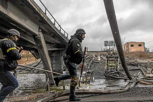 Militares ucranianos caminan sobre un puente destruido por bombardeos en la ciudad de Irpin, provincia de Kiev. 