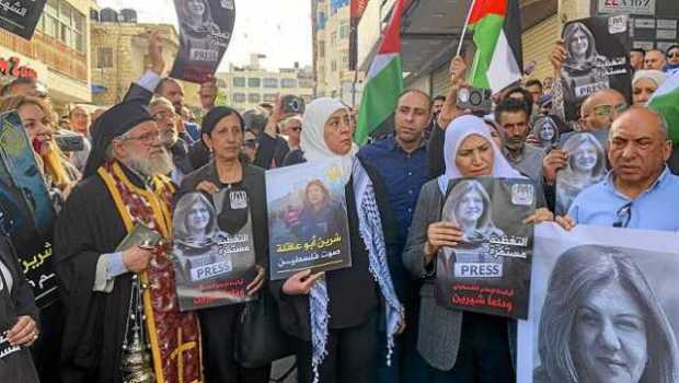 Entre ondeantes banderas palestinas, reclamos de justicia y gritos de "te redimimos, mártir", el cuerpo de la fallecida periodis