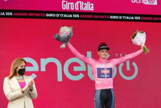 El ciclista holandés Mathieu van der Poel, del equipo Alpecin-Fenix, celebra en el podio, vistiendo la maglia rosa, después de g