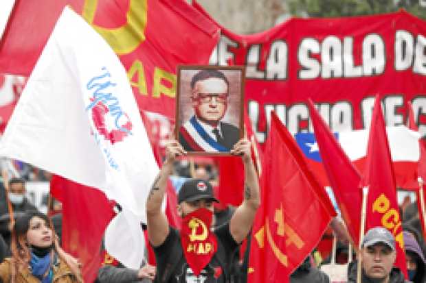 Foto | EFE | LA PATRIA    Una persona sostiene una imagen del expresidente Salvador Allende durante la marcha por la conmemoraci