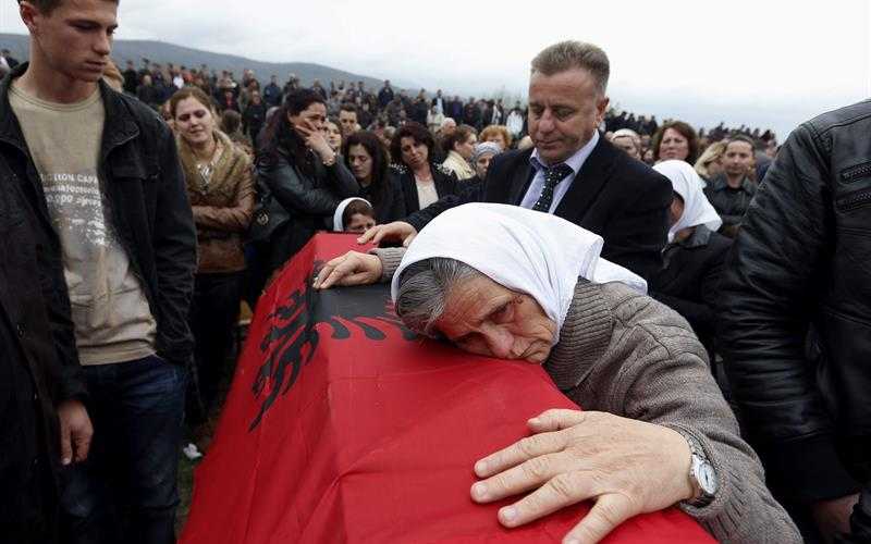 Varios albanokosovares se lamentan durante la ceremonia de entierro de 19 de los 46 albanos asesinados 