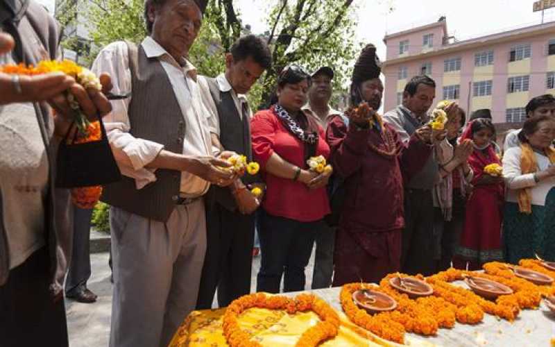 Varias personas participan en un minuto de silencio en memoria de las víctimas mortales del terremoto del pasado 25 de abril en Katmandú (Nepal).