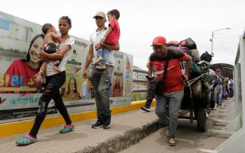 Un grupo de migrantes cruza la frontera en entre Venezuela y Colombia sobre el Puente Internacional Simón Bolívar que une a La P